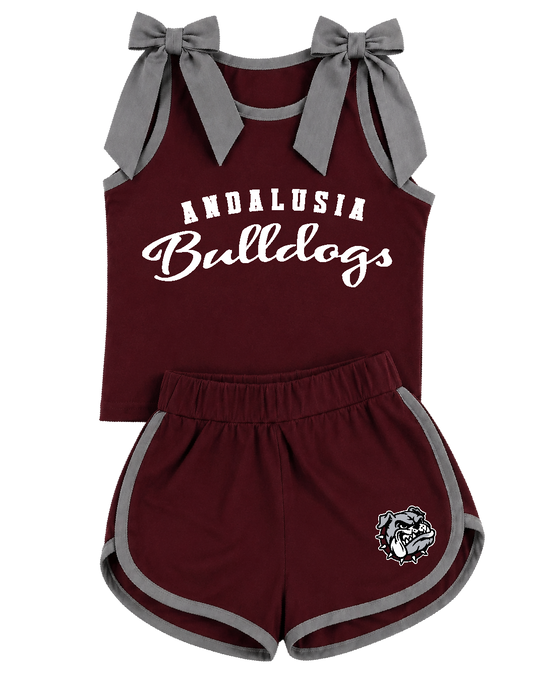 A toddler girl's two-piece athletic outfit set in maroon and gray, featuring a sleeveless top with gray shoulder bows and 'ANDALUSIA Bulldogs' printed in white, paired with matching gray-trimmed shorts and a bulldog logo.